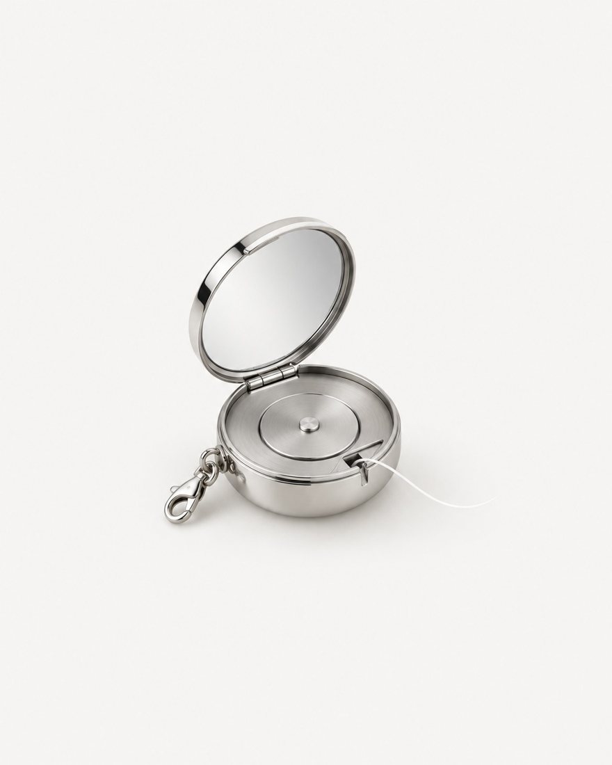 The FIL-O, a round polished steel compact, open to show the mirror and floss